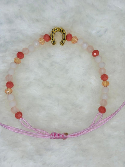PULSERA MARONA CON HERRADURA DORADA ROSA